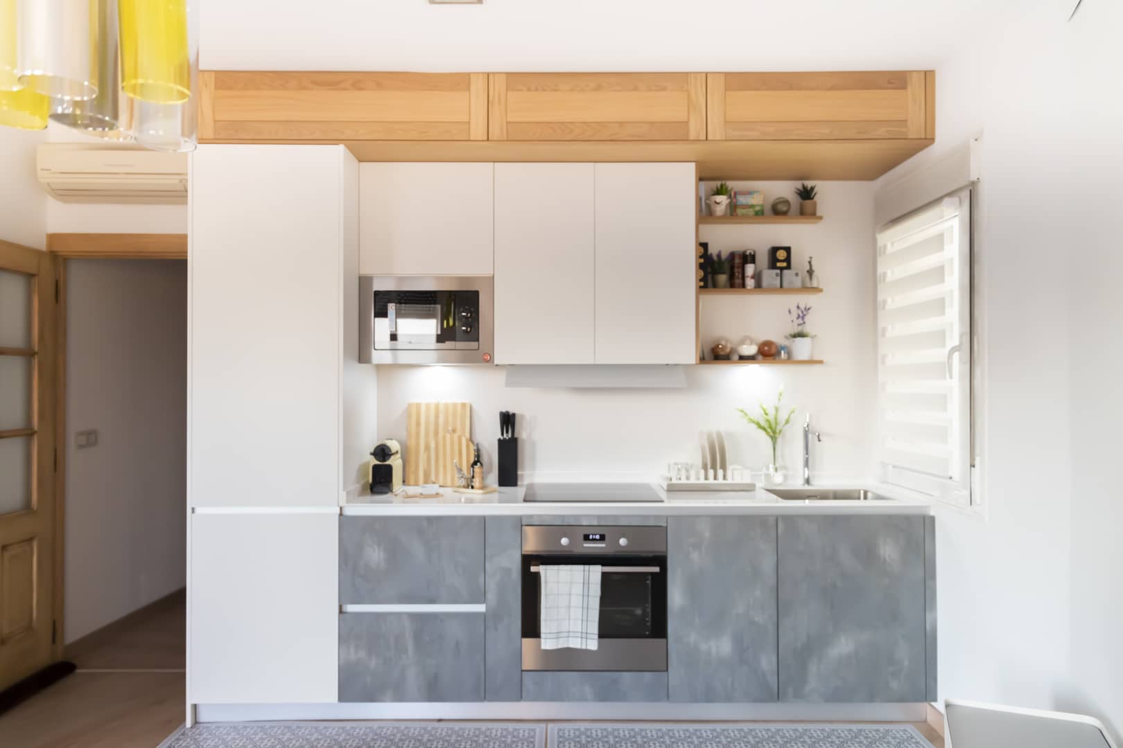 cocina blanca moderna y con madera hasta el techo.