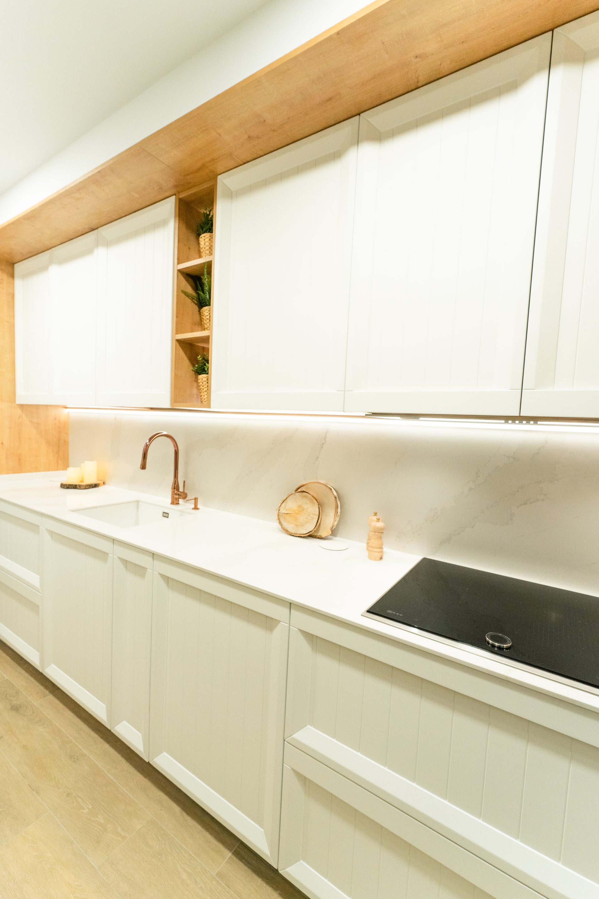 Zona de cocción y fregadero color cobre para complementar el diseño minimalista