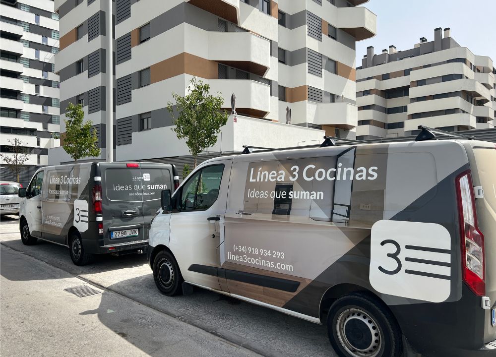 Dos furgonetas de Línea 3 Cocinas aparcadas en la casa de un cliente.