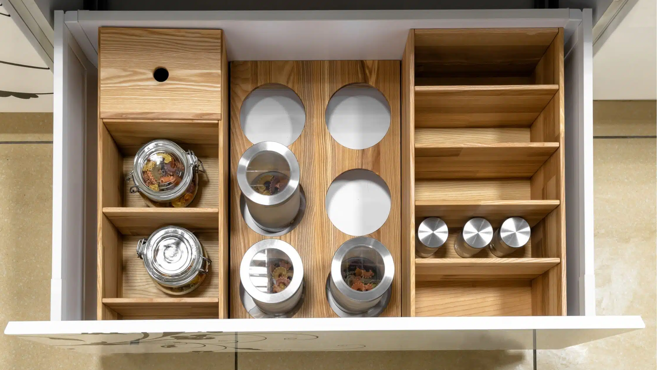 Cajones de cocina organizados con contenedores estilizados.