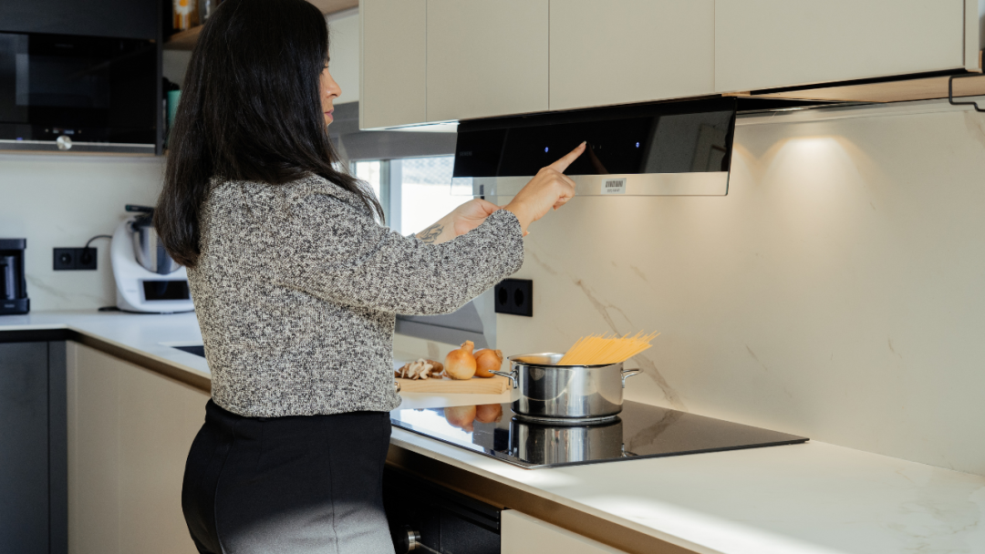 Luz de Bast: una cocina blanca con isla abierta al salón y la entrada.