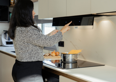 Luz de Bast: una cocina blanca con isla abierta al salón y la entrada.