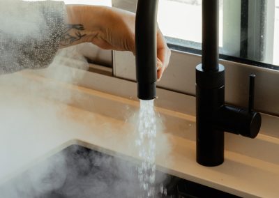 una cocina blanca con isla abierta al salón y la entrada