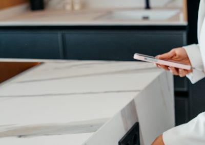 Encimera Porcelánica modelo Sierra Nevada de 1,2 cm de grosor en: ­Espacio desayunador y fregadero con chapado ­Isla con dos costados ingletados , forma irregular efecto cascada + regruesada hasta 6 cm