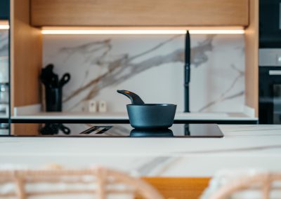 Encimera Porcelánica modelo Sierra Nevada de 1,2 cm de grosor en: ­Espacio desayunador y fregadero con chapado ­Isla con dos costados ingletados , forma irregular efecto cascada + regruesada hasta 6 cm