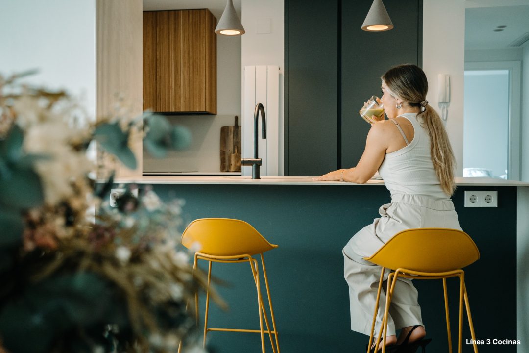 Murmullo de Helechos: una cocina abierta al salón con península en color verde comodoro